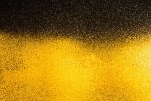 Texture granuleuse abstraite dorée sur fond noir — Photo