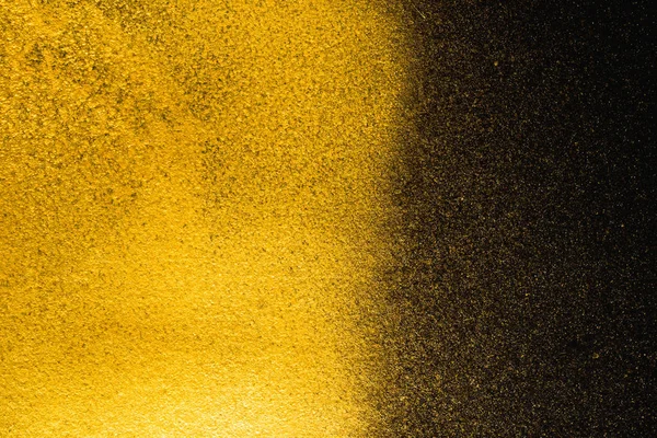 Texture granuleuse abstraite dorée sur fond noir — Photo