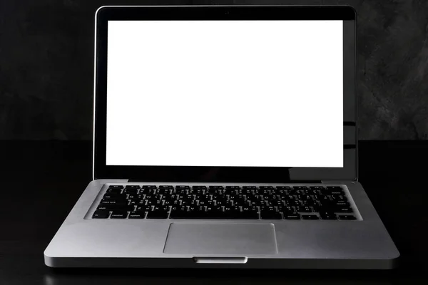 Silver laptop computer with white screen on dark background. Royalty Free Stock Images