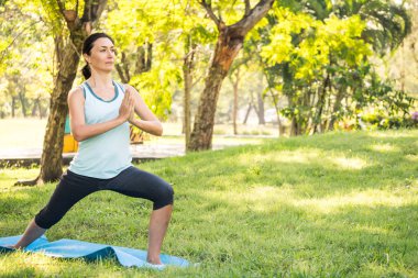 Güzel kadın parkta yoga egzersizleri yapıyor. Sağlıklı yaşam kavramı.