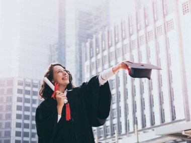 Mezuniyet günü, mezuniyet kapağı ve cüppe holding diploma, başarılı konsepti olan kadın