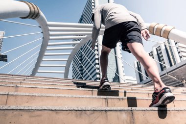 Arkadan görünüş atletik gencin şehir köprüsü üzerinde Bangkok kentsel sahne arka plan ile sabah koşan sportif adam koşu
