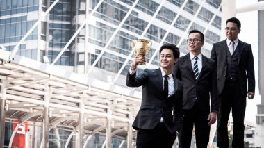 Altın Kupa cup için onların kazanan iş proje ile mutlu Asya iş adamları. Takım çalışması ve başarı kavramı