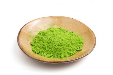 Seramik tabak beyaz zemin üzerine yeşil çay tozu.