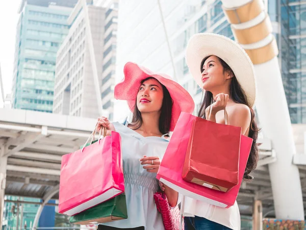 Mujeres jóvenes felices con bolsas de compras disfrutando en las compras, chicas asiáticas se están divirtiendo con sus compras en la ciudad. Concepto de consumo y estilo de vida —  Fotos de Stock