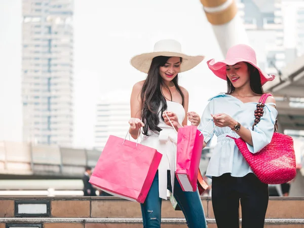 Mujeres jóvenes felices con bolsas de compras disfrutando en las compras, chicas asiáticas se están divirtiendo con sus compras en la ciudad. Concepto de consumo y estilo de vida —  Fotos de Stock