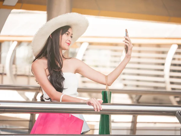 Mulher bonita fazendo auto-retrato por telefone inteligente depois de desfrutar em compras. Consumismo e conceito de estilo de vida — Fotografia de Stock