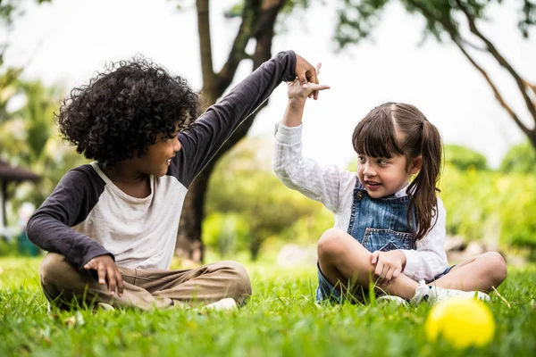 Kisfiú és a lány játszik együtt, egy park — Stock Fotó