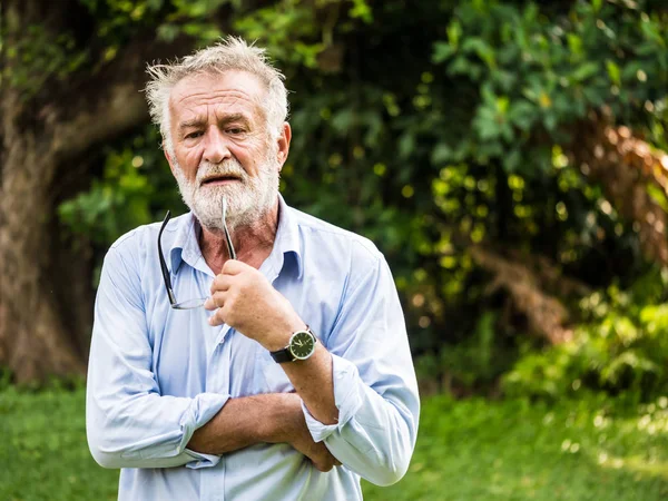 Portrait of Thoughtful senior man in a park. — Stock Photo, Image