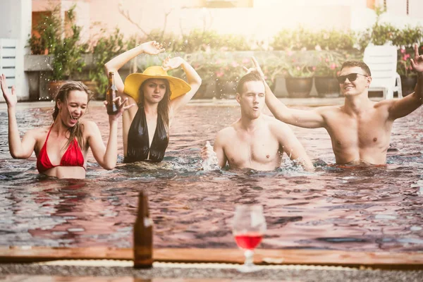 Group of friends enjoying vacation in summer time. Young people having fun dancing in swimming pool — Stock Photo, Image