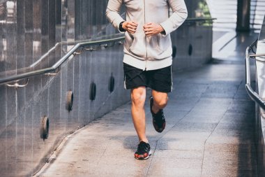 Atletik gencin şehir köprüde sabah koşu yakın çekim.