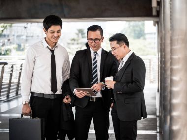 İş arkadaşları konferans kahve molası sırasında sohbet grubu. Asya iş erkek birlikte iken ofis binası önünde duran konuşuyor.