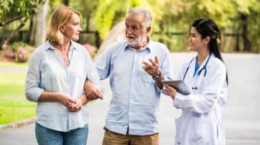 Yaşlı çift bir parkta Tıbbi Danışma söz doktorla. Sağlık kavramı