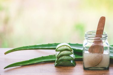 Taze aloe vera ve jöle doğa arka plan ile ahşap masa üzerinde cam şişede