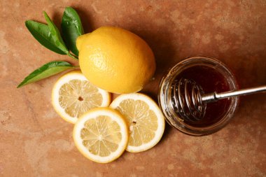 Bir bardak bal ayı ve kahverengi grunge zemin üzerine limon ile. Üstten Görünüm