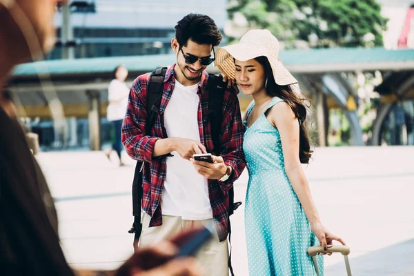 一对亚洲旅行者正在城市街道上漫步, 从智能手机上寻找有趣的地方。假期和技术概念 — 图库照片