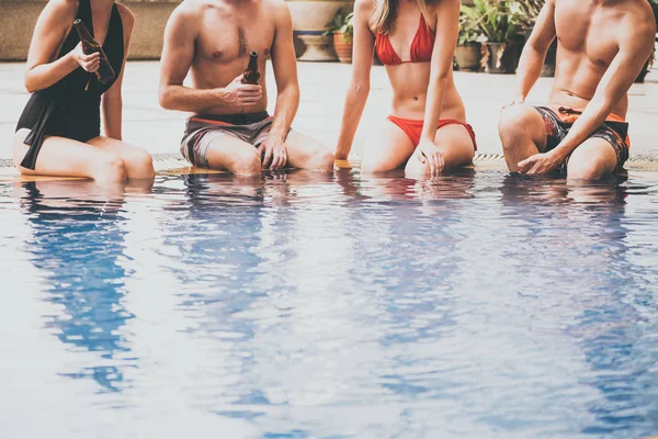 Grupp vänner njuter av sommaren i en pool. — Stockfoto