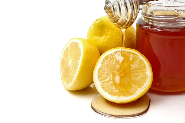 Un vaso de miel con cazo y limón sobre fondo blanco —  Fotos de Stock