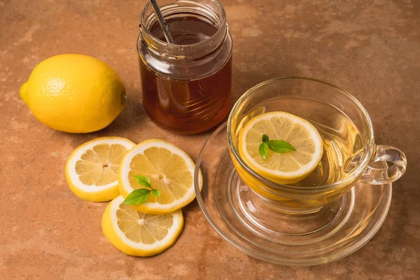 Чашка чая с лимоном и медом на коричневом фоне гранжа . — стоковое фото