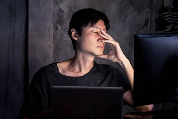 Cansado e exausto jovem trabalhando no computador em casa à noite — Fotografia de Stock