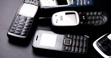Siyah arka planda eski model cep telefonları..