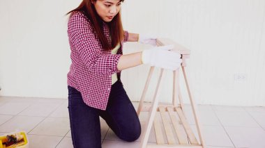 Kadın marangoz, tahta parçalarını bir araya topluyor..