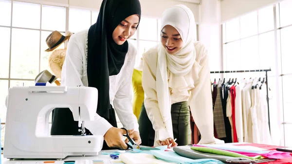 Beautiful muslim women working together at the clothing office.