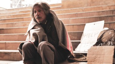 Evsiz adam merdivenlerde oturuyor..