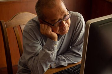 Asyalı işadamı ofiste oturup çalışmalarını analiz ediyor..