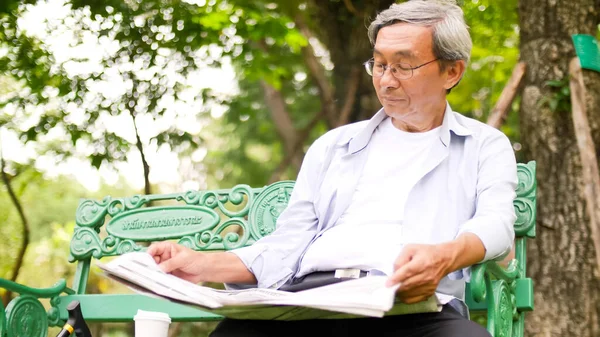 Happy Asian Man Sitting Bench Reading Newspaper Park — Stock Photo, Image