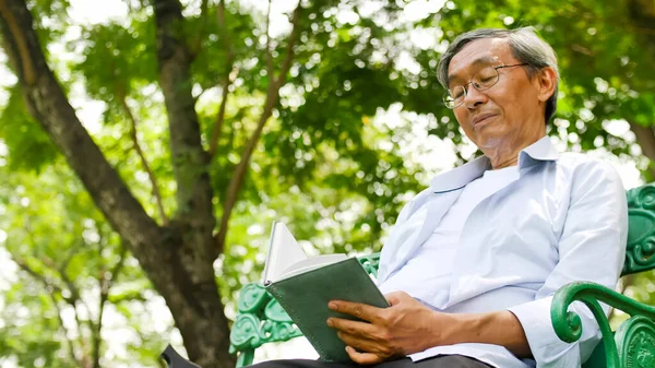 Happy Asian Man Sitting Bench Reading Book Park — Stock Photo, Image