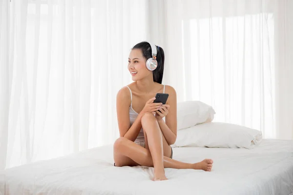 Mujer Sexy Escuchando Música Desde Smartphone Sentada Una Cama Dormitorio —  Fotos de Stock