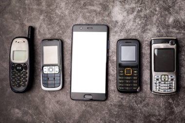 Pek çok eski cep telefonu ve grunge arka planda bir akıllı telefon..