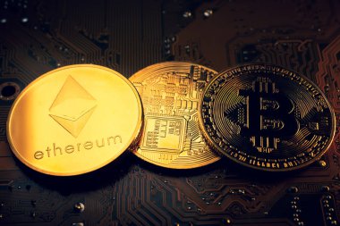 Üzerinde ethereum ve bitcoin sembolü olan altın sikkeler..