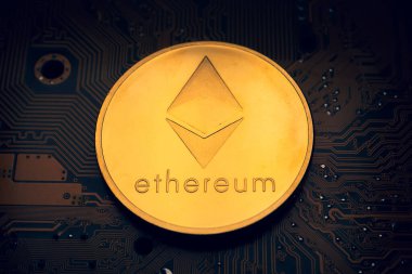 Üzerinde ethereum sembolü olan altın bir sikke..