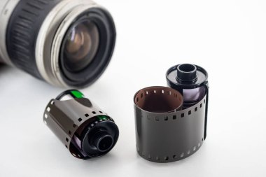 Tek lensli refleks kamera ve film beyaz arkaplanda dönüyor.