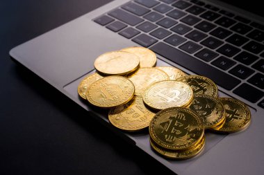 Bilgisayarında bitcoin sembolü olan altın paralar.