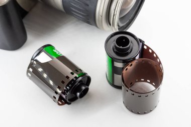 Tek lensli refleks kamera ve film beyaz arkaplanda dönüyor.