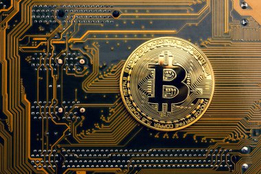 Üzerinde bitcoin sembolü olan altın bir sikke..