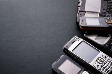 Siyah arka planda eski ve eski cep telefonları.