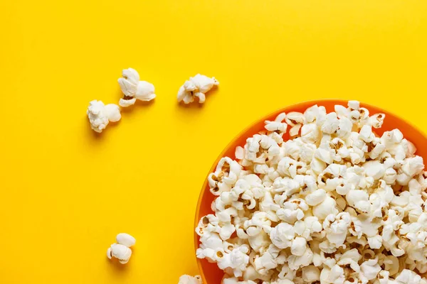 Popcorn in an orange bowl.