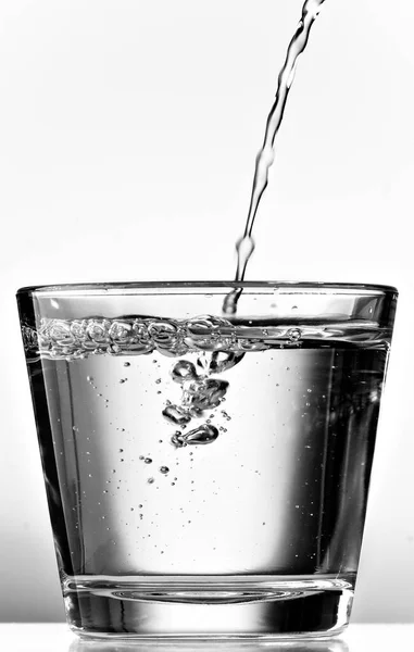 Verter Agua Una Taza Vidrio Sobre Fondo Blanco Blanco Negro — Foto de Stock