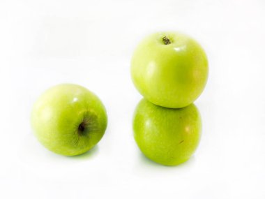 Üç küçük yeşil elma dengeleniyor.