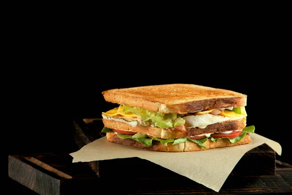 Smörgås med skinka, ost, tomater, sallad och rostat bröd. — Stockfoto