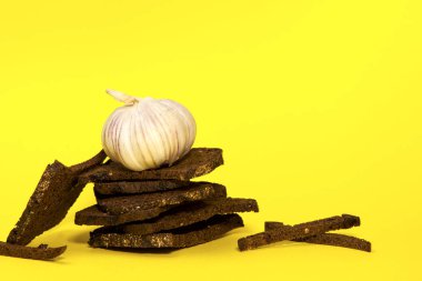 Çavdar ekmeği ve sarı arka planda sarımsak. Bira aperatifi. Boşluğu kopyala.