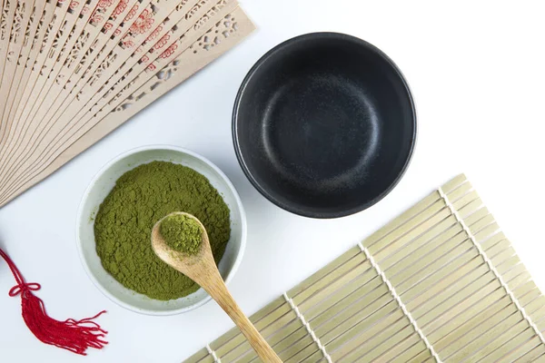 Matcha Japanese tea. Two tea bowls and a bamboo spoon with powder on a light background. Tea ceremony. Copy space.