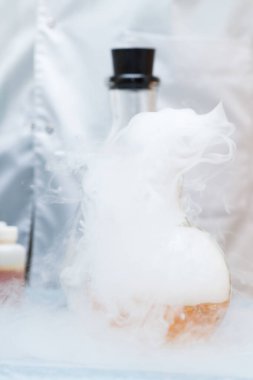 Reaksiyonlu laboratuvar şişesi. Tecrübeler. Araştırma yapıyorum. Yüksek miktarda gaz veya buhar salınımı ile kimyasal reaksiyon. Seçici odaklanma. Yakın çekim..