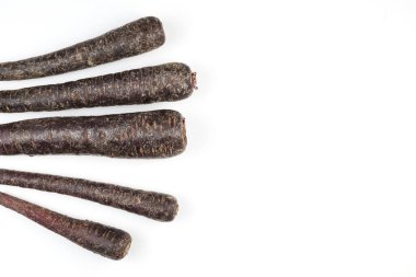 Rengarenk sebzeler. Açık arkaplanda soyulmamış mor havuç seti. Boşluğu kopyala.