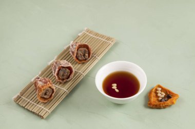 Sujeonggwa, tarçınlı Kore pançı ve kurutulmuş hurma. Koyu kırmızımsı kahverengidir ve genellikle çam fıstığı ile süslenir (kurutulmuş hurma). Soğumuş sarhoş..