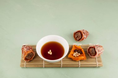 Sujeonggwa geleneksel bir Kore soğuk içeceğidir. Koyu kırmızı kahverengidir, kurutulmuş hurma ağacından yapılır ve genellikle çam fıstığıyla süslenir..